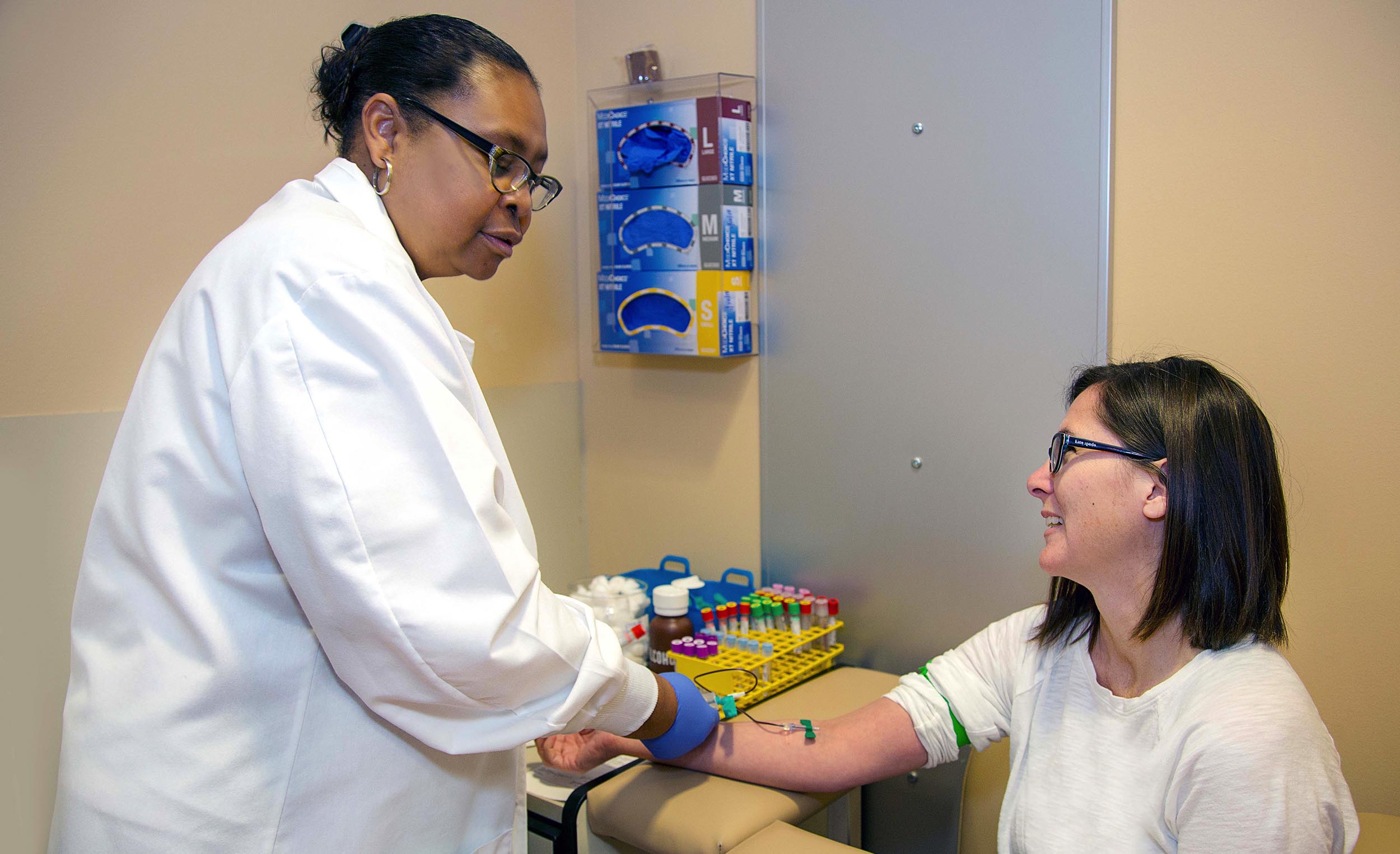 Nurse performing blood work to a patient image